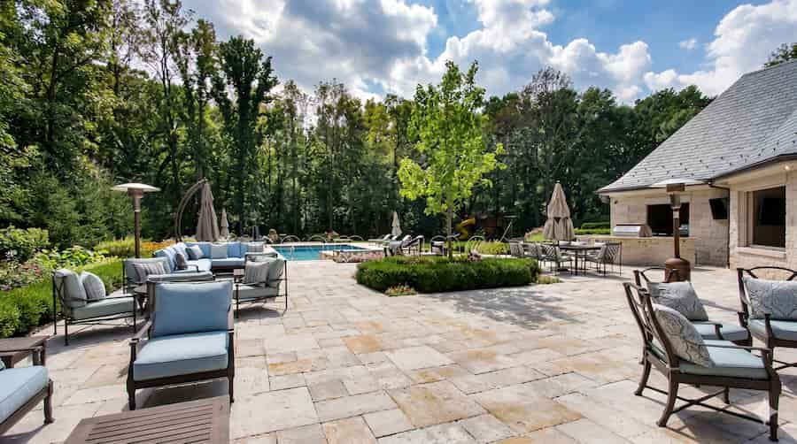 Premium backyard stone patio with pool and outdoor seating area